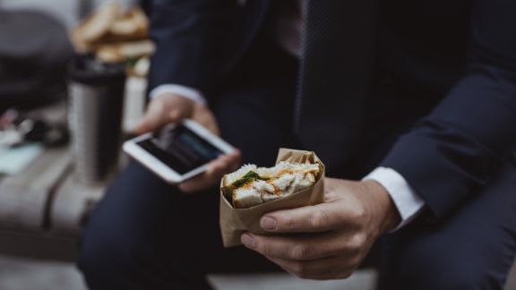 Mand_med_mobil_og_sandwich_feature_576x324
