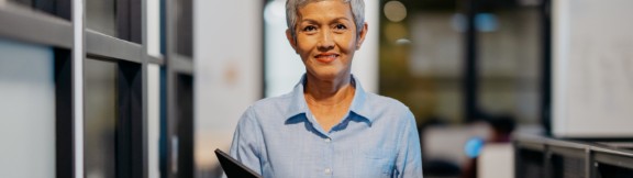 Kvinde med gråt hår holder bærbar computer