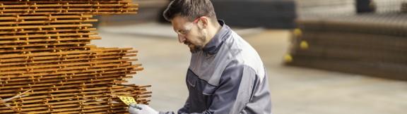 Mand inspicerer jern på fabrik