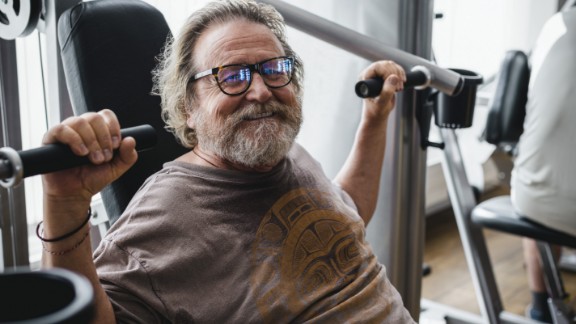 Ældre mand smiler og træner i fitness