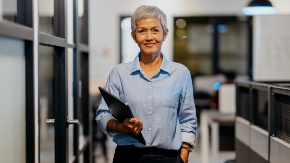 Kvinde med gråt hår holder bærbar computer
