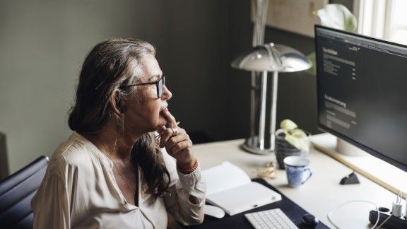 Kvinde med en arm kigger på sin computer