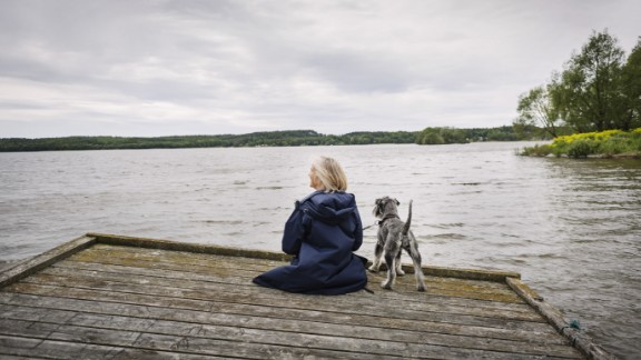 Kvinde med hund kigger ud fra badebro