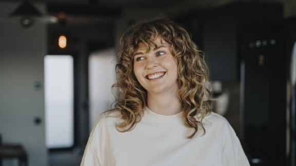 En kvinde med krøller smiler