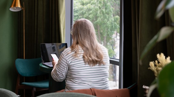 En kvinde sidder og kigger på sin mobil