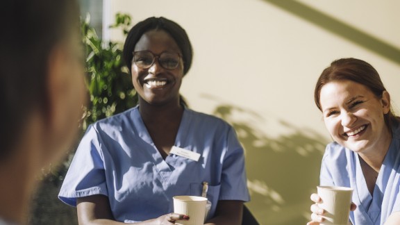 To kvinder, som arbejder på et hospital, griner