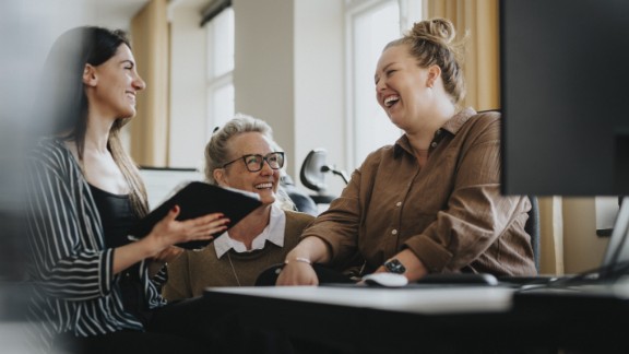Kvindelige kollegaer griner sammen