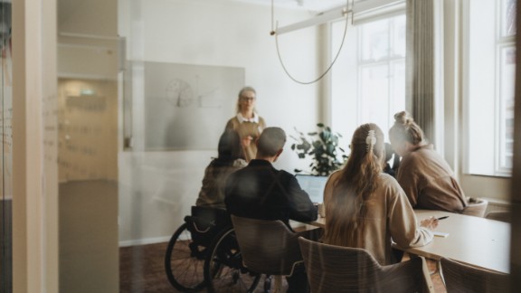 Mand i kørestol sidder til møde