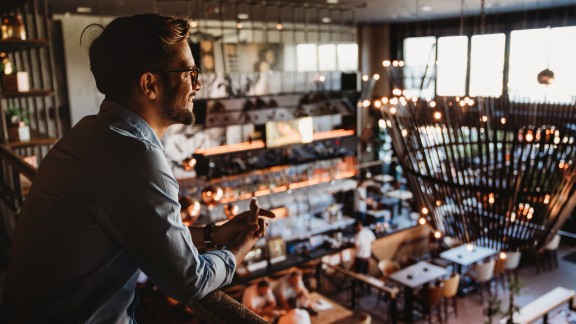 Mandlig restaurantejer kigger ud over restaurant