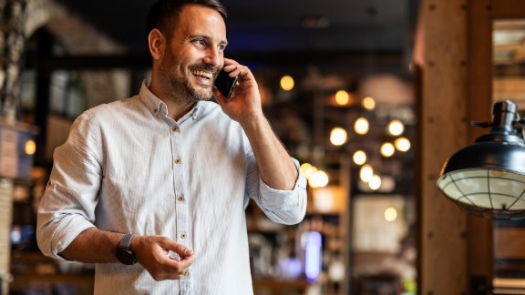 Mandlig kok taler i telefon og smiler