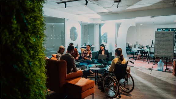 Kvinde i kørestol sidder til møde