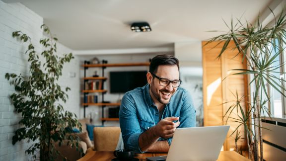 Mand_smiler_ved_computer_feature_576x324