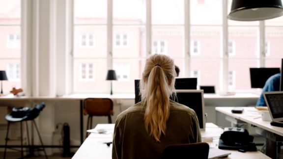 Kvinde_arbejder_ryggen_til_text-image-50_50_576x324