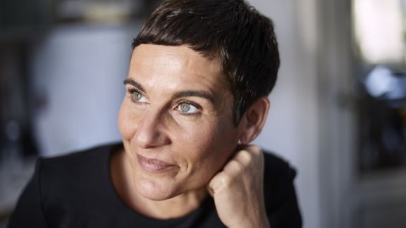 Kvinde_smiler_eftertaenksomt_text-image-50_50_576x324