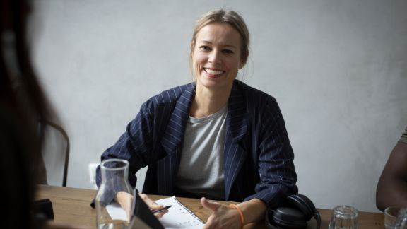 Kvinde_smiler_i_moede_text-image-50_50_576x324