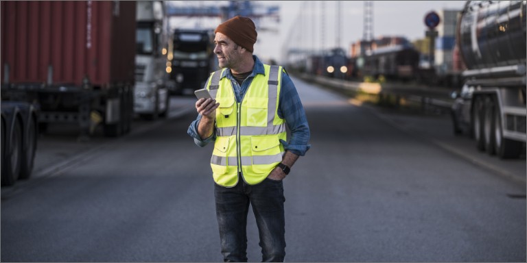 mand_i_vest_taler_i_telefon_container_content-header_768x384