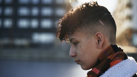 Dreng kigger med rødt halstørklæde