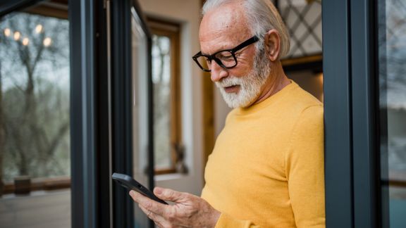 ldre_mand_holder_telefon_feature_576x324