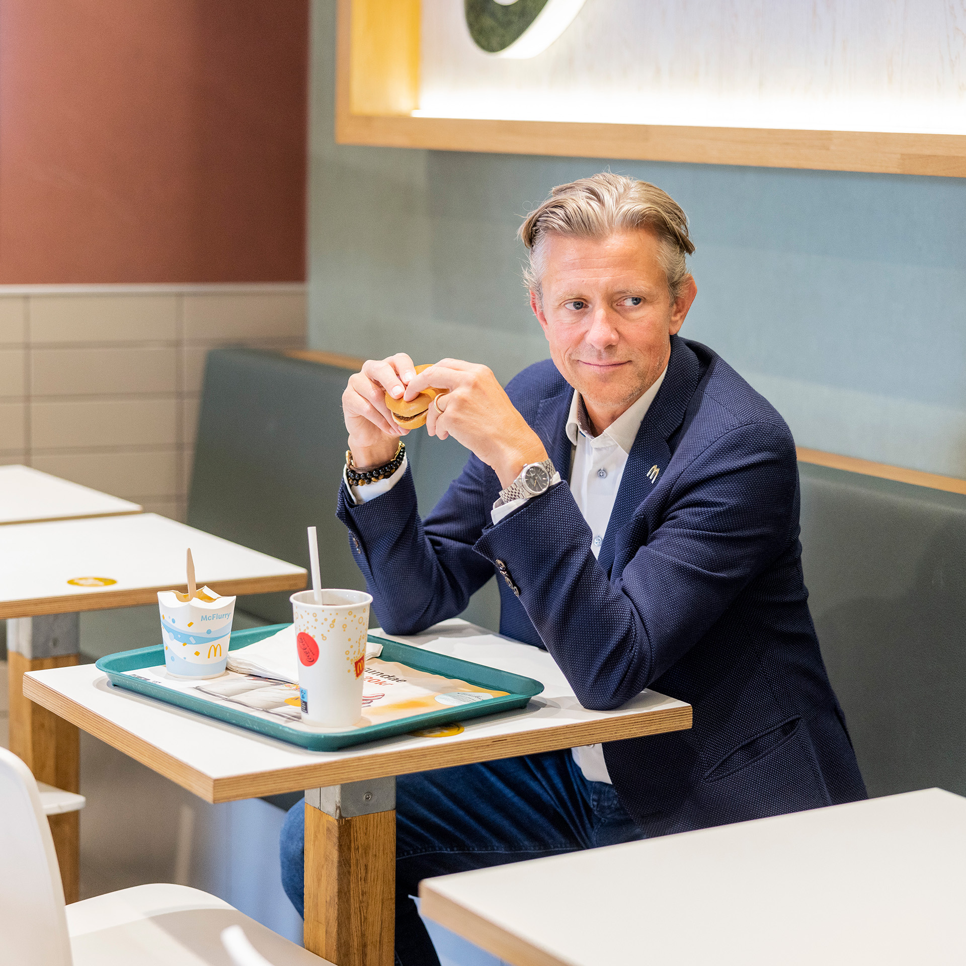 Mads Friis sidder og spiser burger på McDonalds