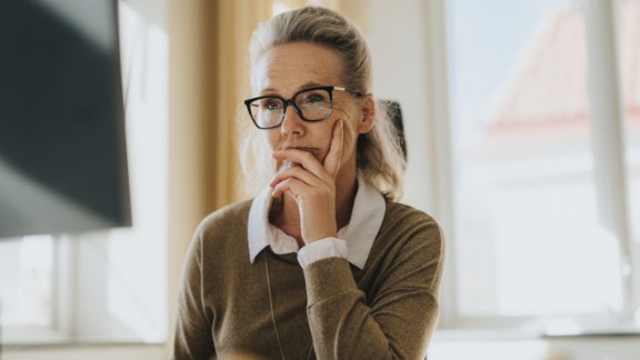 Kvinde med briller kigger koncentreret på en computer