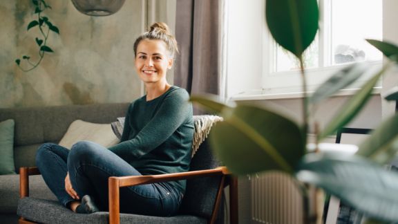 Kvinde_smiler_i_sofa_article-card_576x324