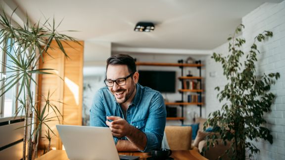 Mand_smiler_ved_computer_article-card_576x324