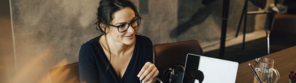 Kvinde_sidder_ved_skrivebord_expand-box_576x162