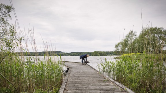 Kvinde med hund ved sø