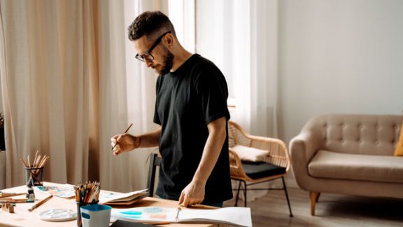 Mand_maler_ved_skrivebord_article-card_576x324