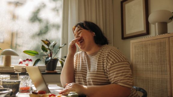 Kvinde_arbejder_hjemme_griner_feature_576x324