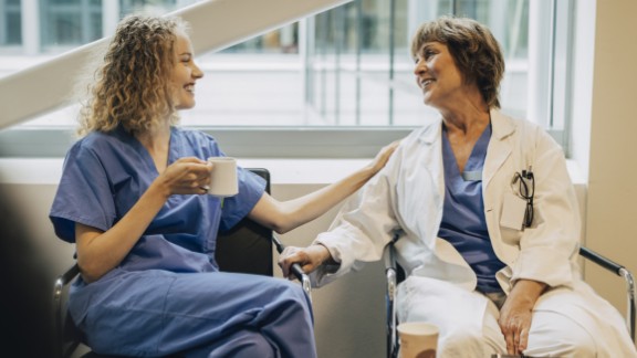 Læge og sygeplejerske drikker kaffe og snakker