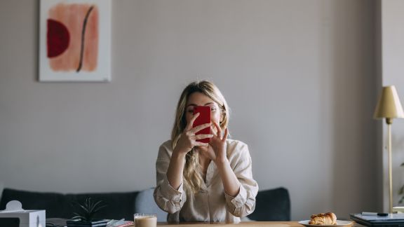 Kvinde_med_mobil_foran_ansigtet_text-image-50_50_576x324