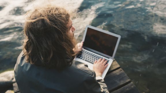 Mand_med_computer_havet_text-image-50_50_576x324