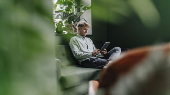 Mand_med_iPad_sofa_text-image-50_50_576x324