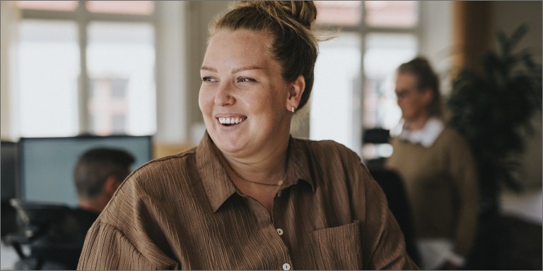 En kvinde i brun skjorte griner