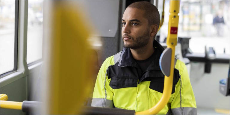 Mand i uniform sidder i bussen