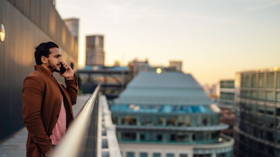 Mand_taler_i_telefon_balkon_article-card_576x324