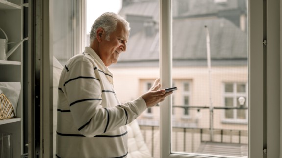 Mand med stribet trøje kigger på telefon 