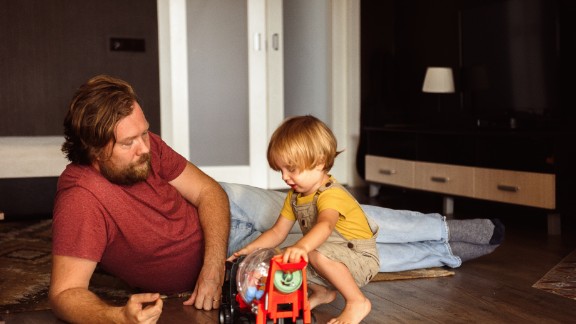Far og søn leger på gulvet