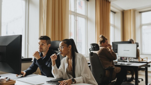 To kollegaer sidder foran en computer