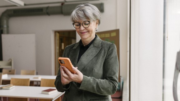 Kvindelig skolelærer kigger på telefon