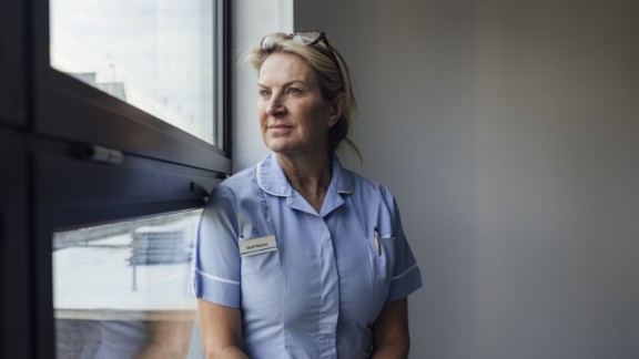 Kvindelig sygeplejerske kigger ud ad vindue