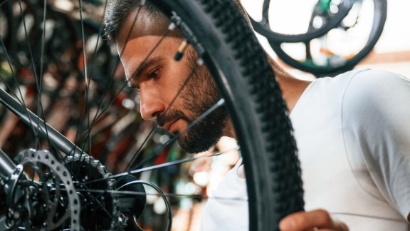 Mand reparerer cykel på cykelværksted