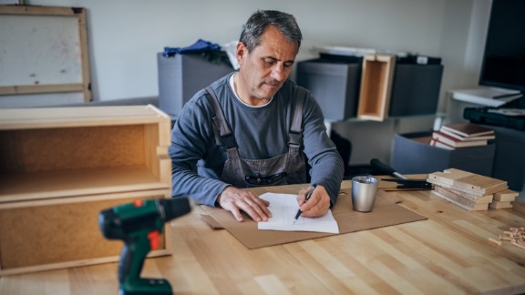 Mand sidder på kontor og laver tegninger til håndværk