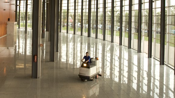 Mand kører gulvmaskine indendørs