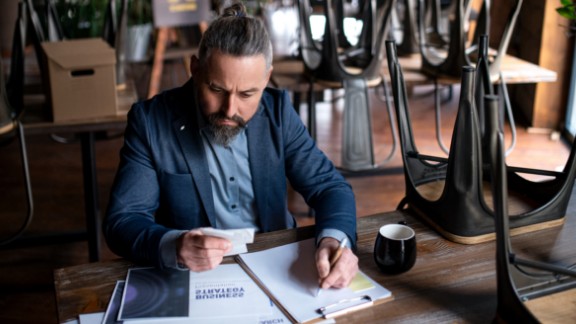 Mandlig restaurantejer laver regnskab