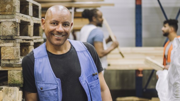 Mand på trælager smiler til kamera