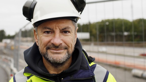Mand med hjelm og vest på byggeplads