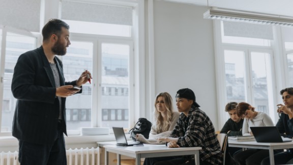 Mandlig skolelærer underviser gymnasieklasse