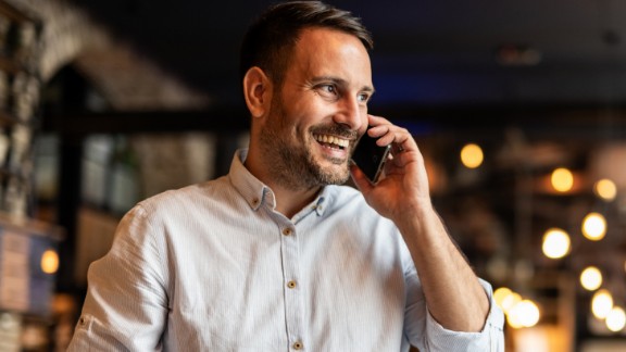 Mandlig kok taler i telefon og smiler